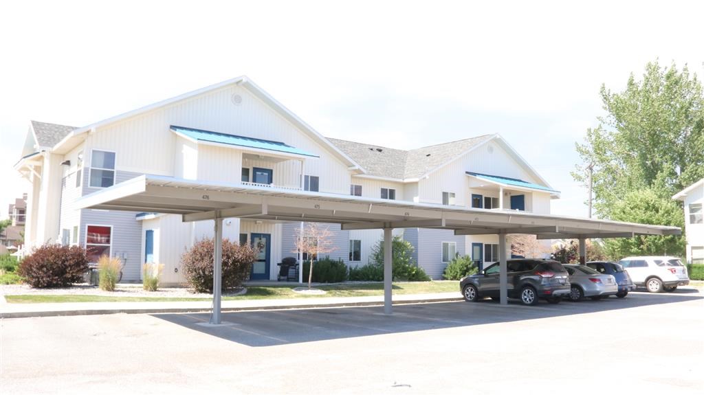 a white house with cars parked in a parking lot