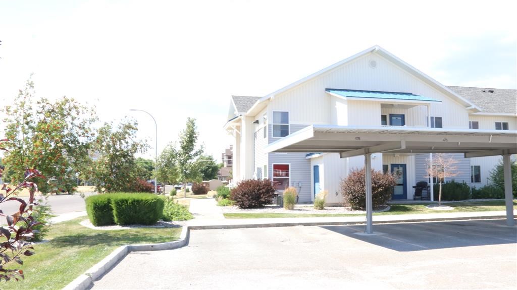 a white house with a covered porch and a driveway