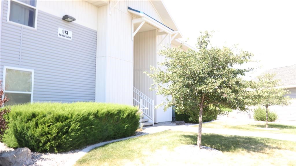 an apartment building with a tree in front of it