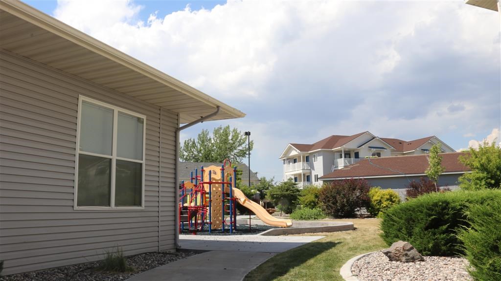 a playground in a backyard of a house with a slide