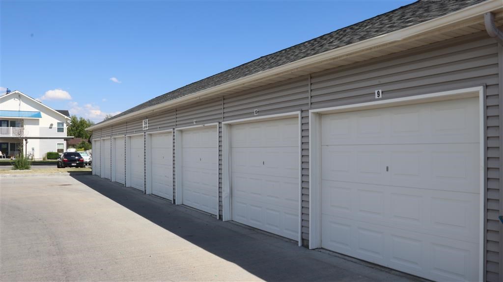 a row of white garage doors on the side of a building