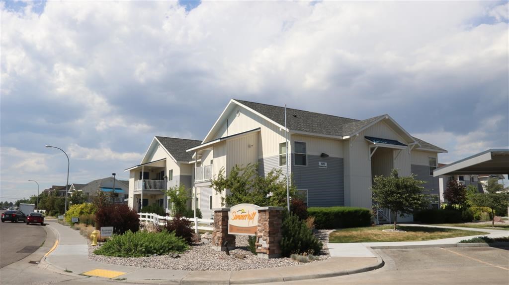 a building with a sign and cars parked in front of it
