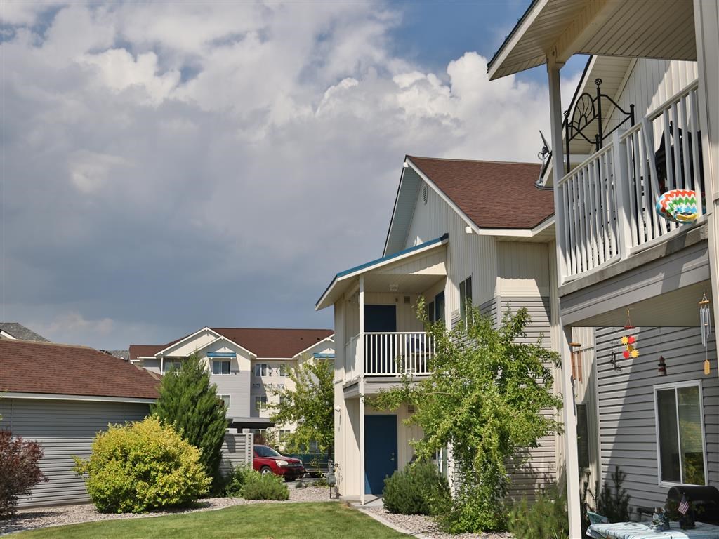 a row of houses with a porch and a cloudy sky