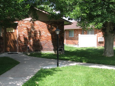 a sidewalk in front of a brick house