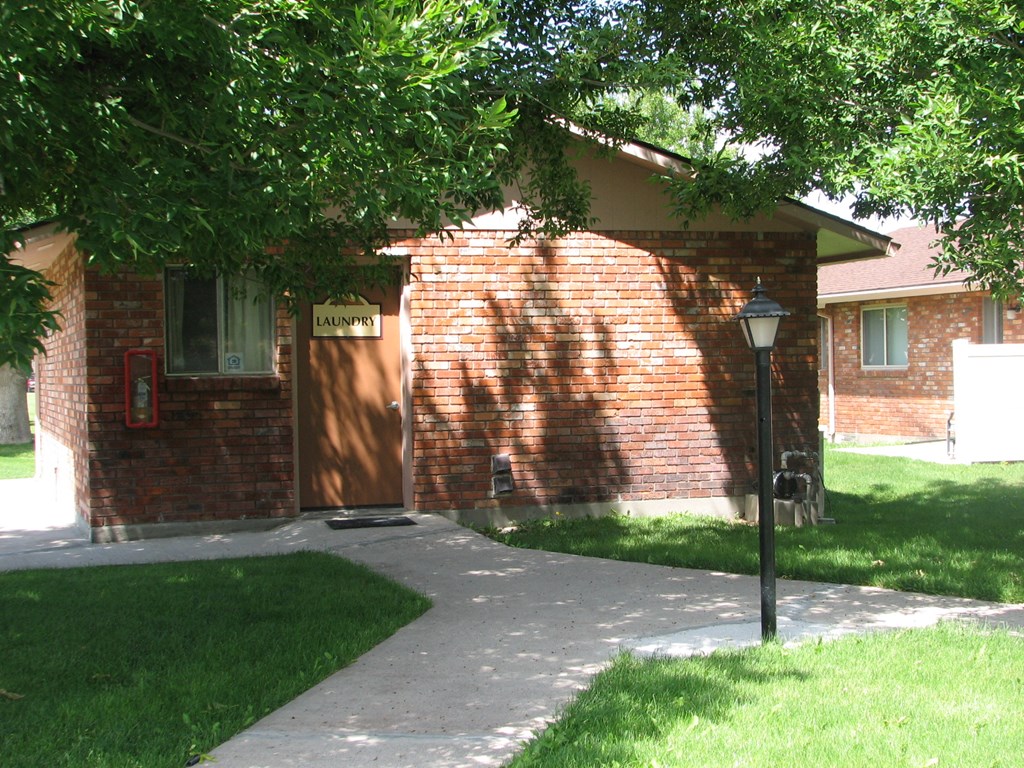 a brick house with a sidewalk in front of it
