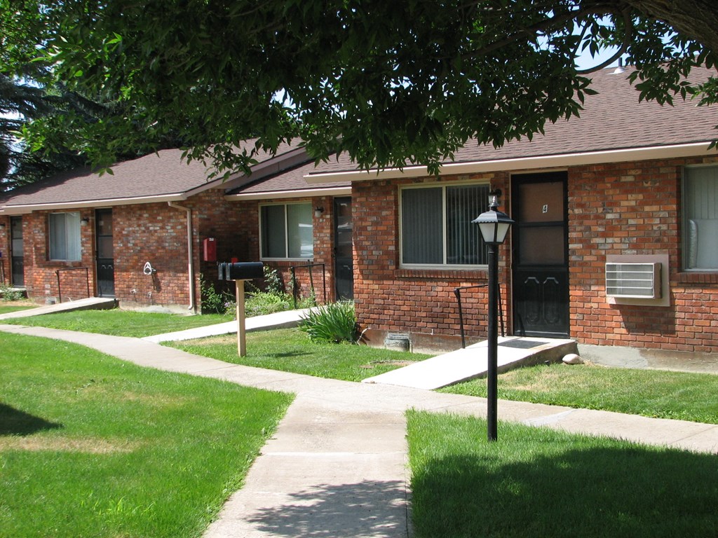 a sidewalk in front of a brick house