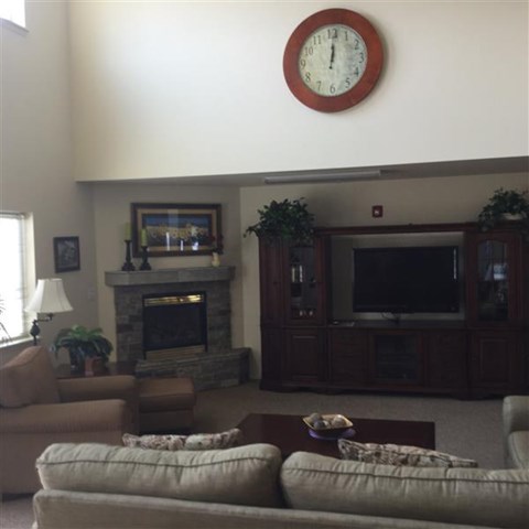 a living room with a couch and a clock on the wall