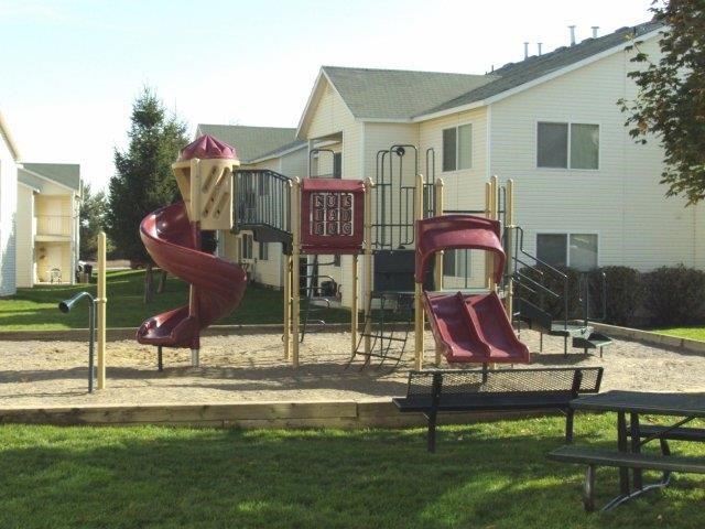 a playground with two slides and a house