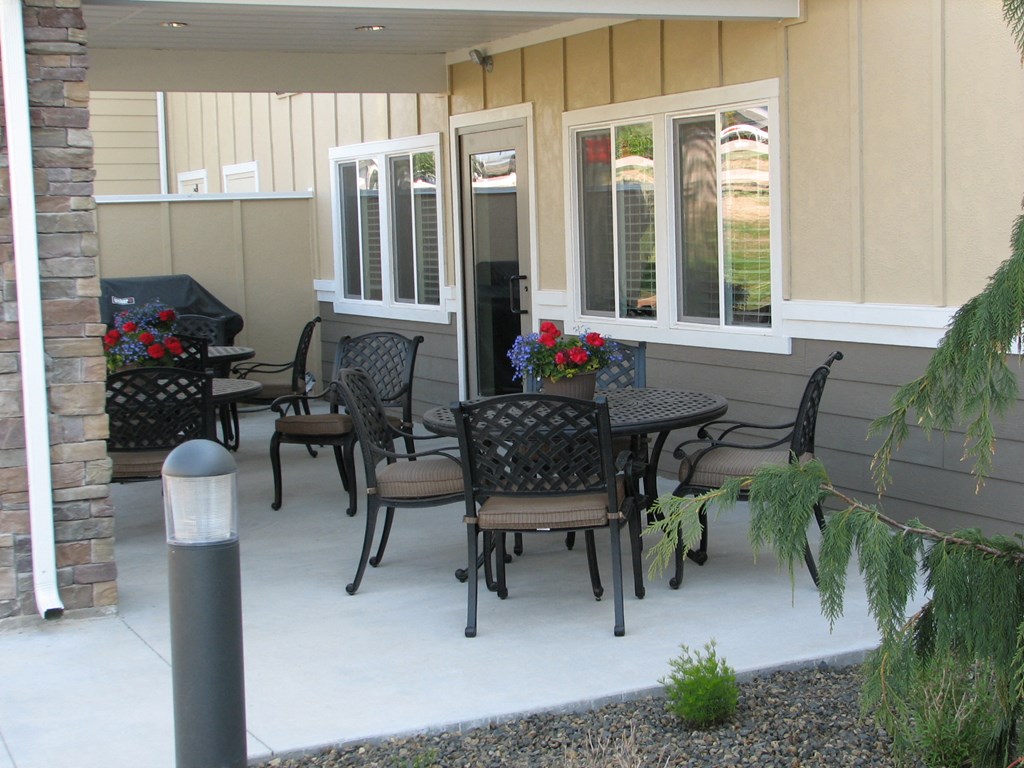 a patio with a table and chairs outside of a house