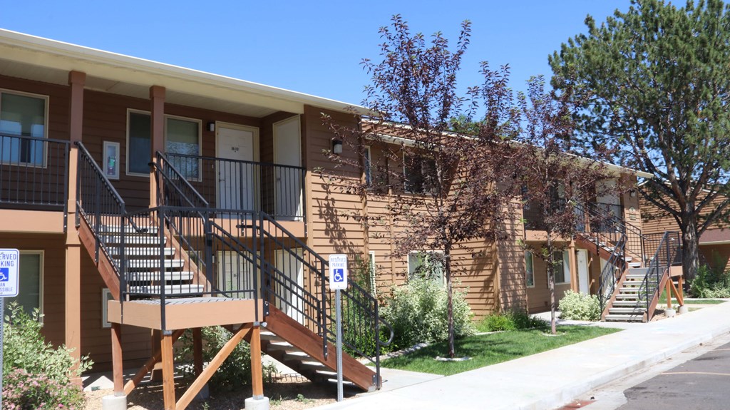 the front of an apartment building with stairs and a porch