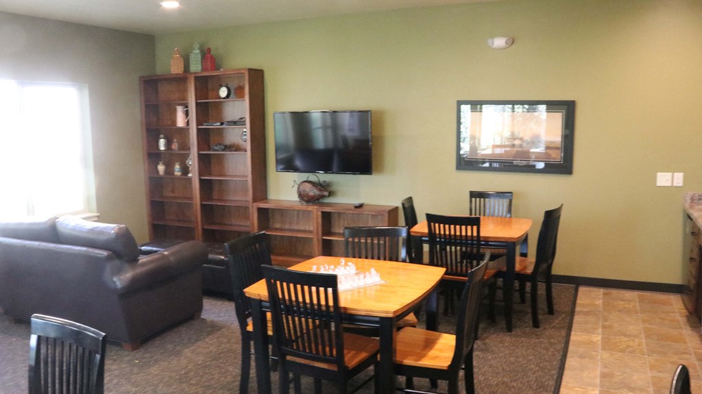 a dining room and living room with a table and a tv