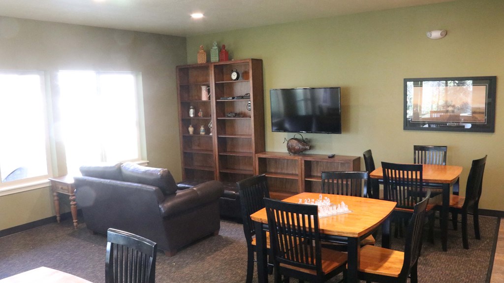 a living room with a table and chairs and a tv