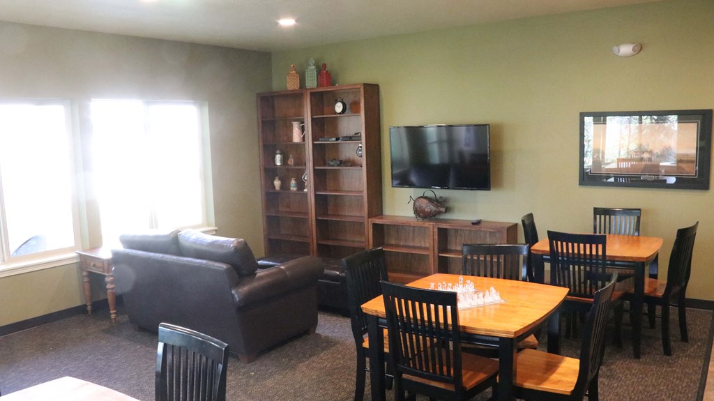 a living room with a table and chairs and a television