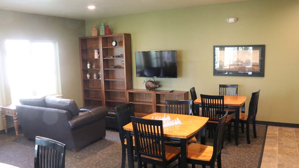 a living room with a table and chairs and a tv