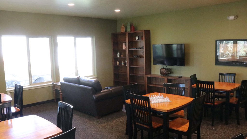 a dining room and living room with a table and chairs and a tv