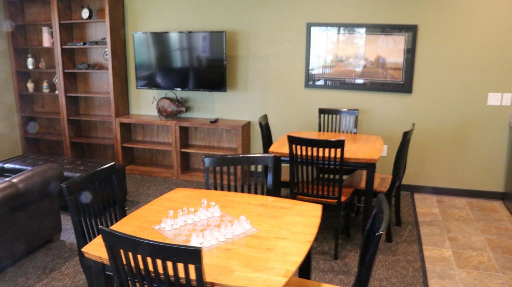 a dining room with tables and chairs and a flat screen tv