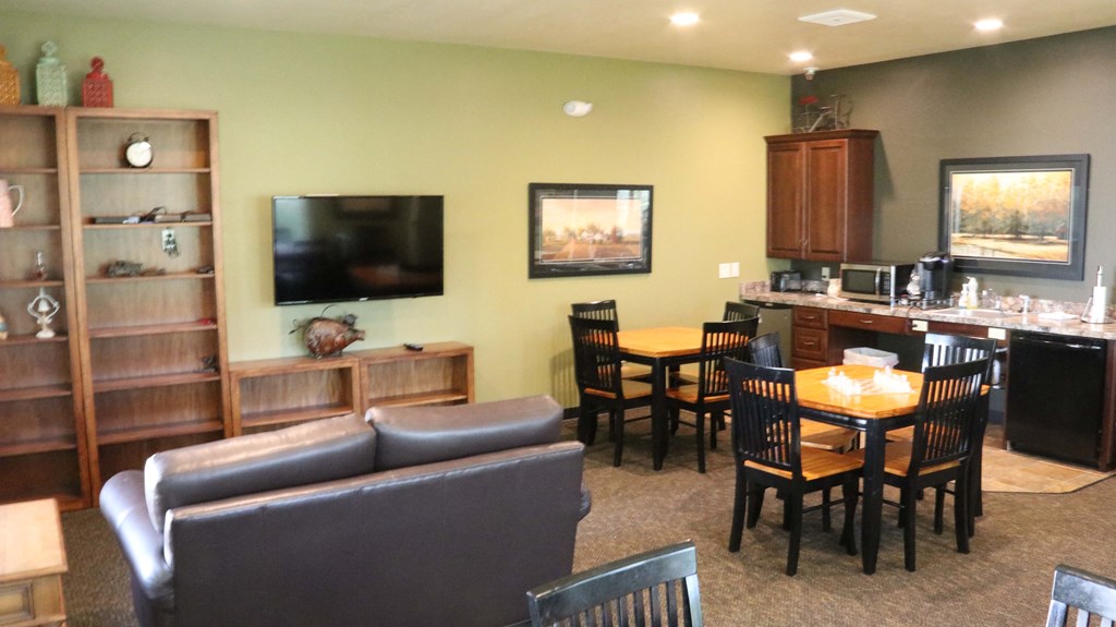 a living room and kitchen with a table and chairs and a television