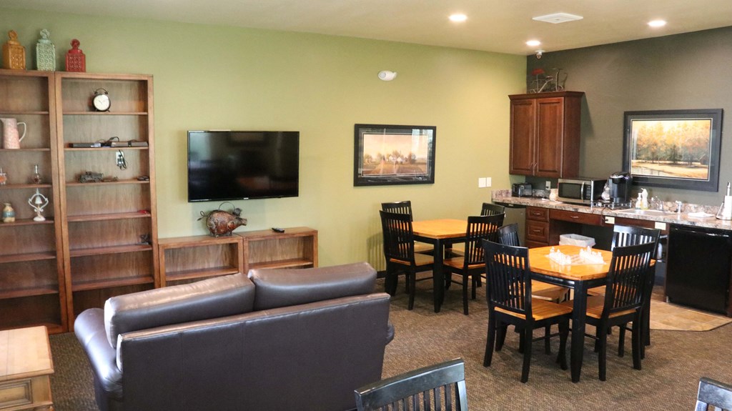 a living room and kitchen with a table and chairs and a television
