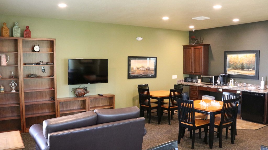 a living room and kitchen with a table and chairs and a television