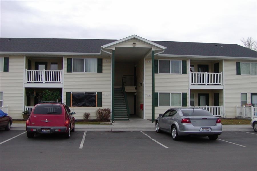 a apartment building with cars parked in a parking lot