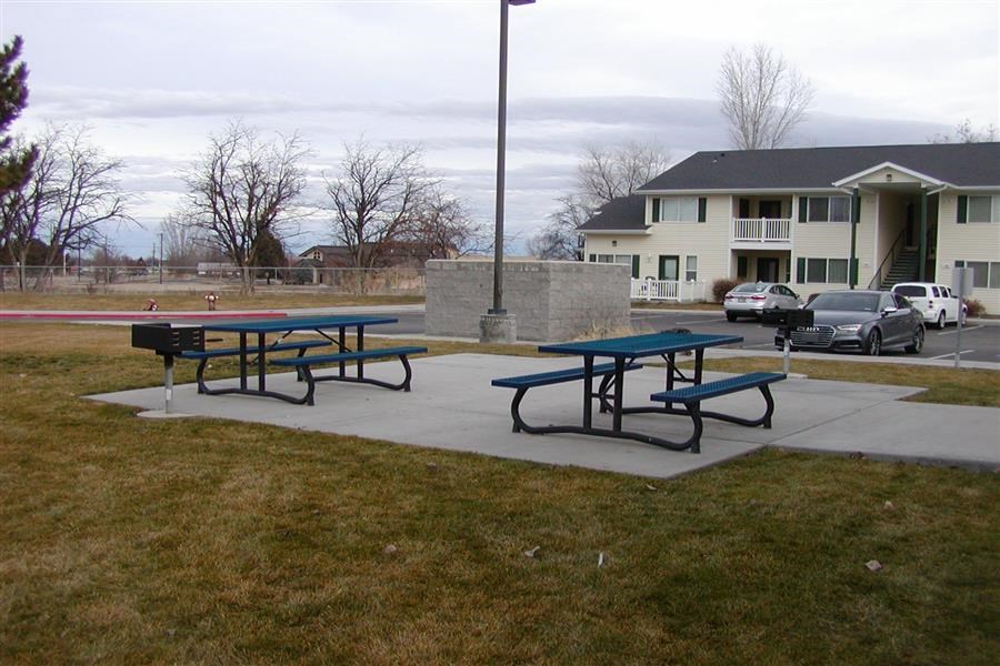 two picnic tables in front of a building
