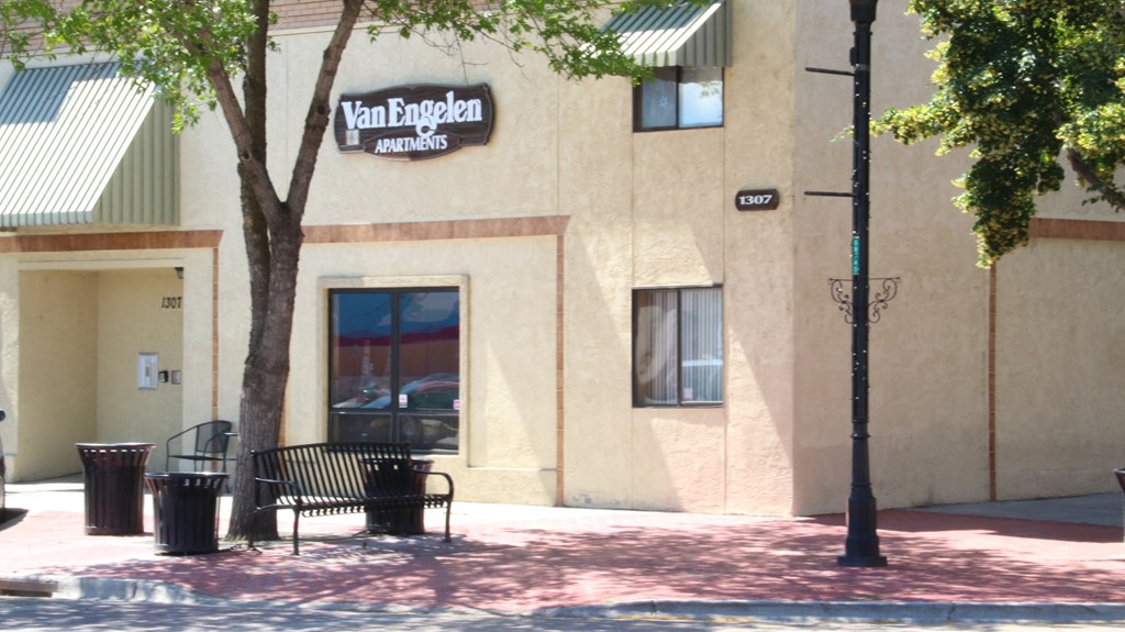a building with a bench and a tree in front of it