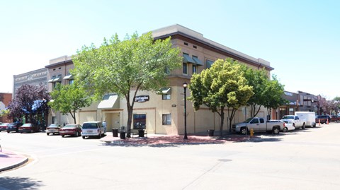 an office building with a parking lot and trees