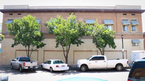 the side of an old building with trees in front of it
