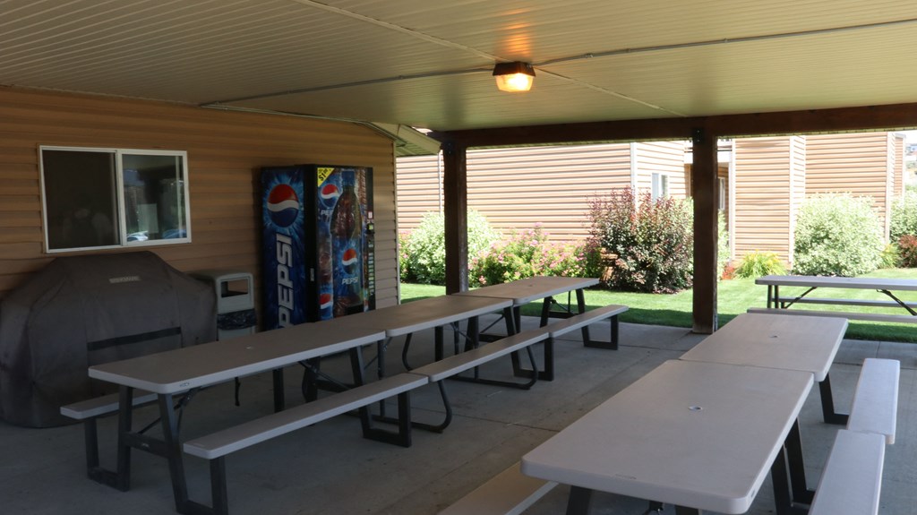 a covered picnic area with benches and tables