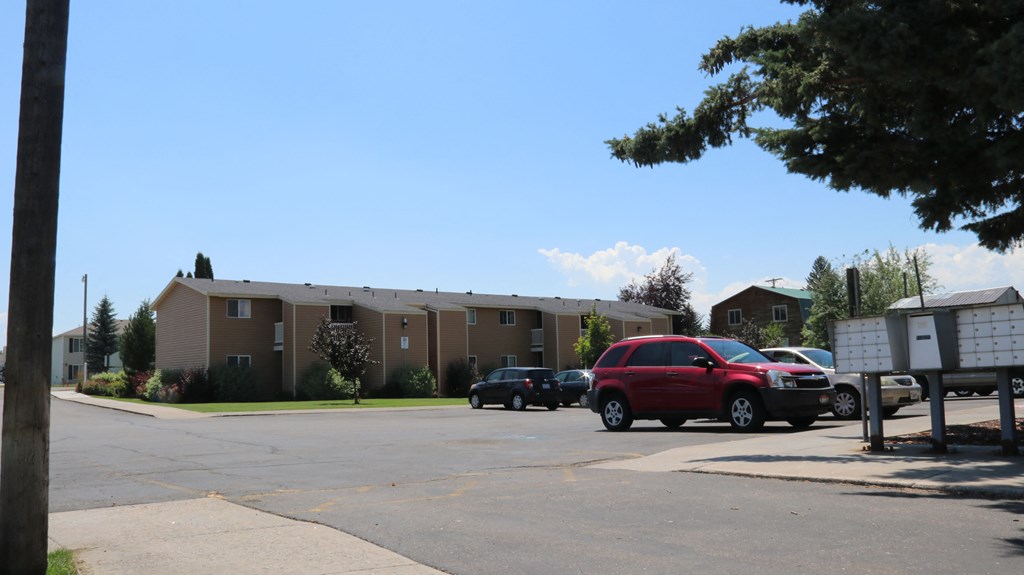 a parking lot with cars in front of an apartment building