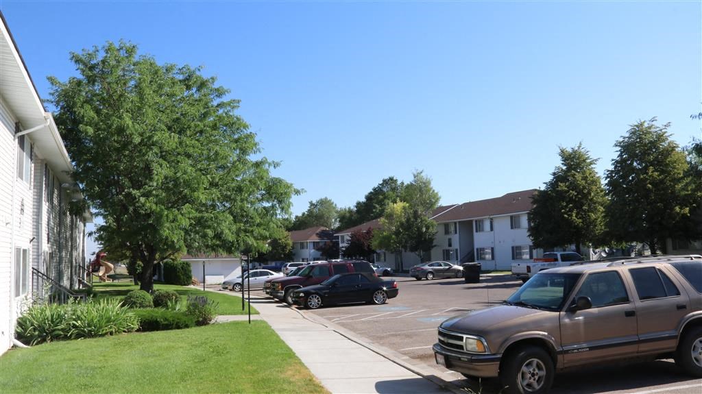 a parking lot with cars parked in front of a house