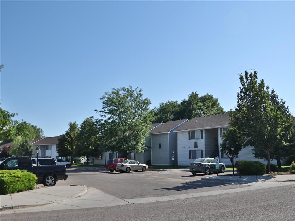 a city street with cars parked in front of apartment buildings