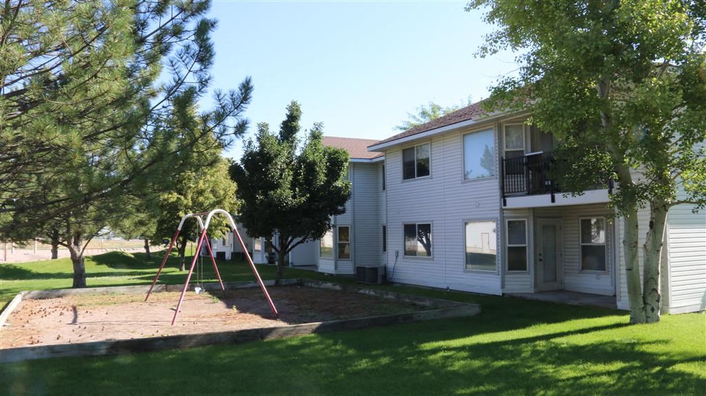 a swing set in a yard in front of a house