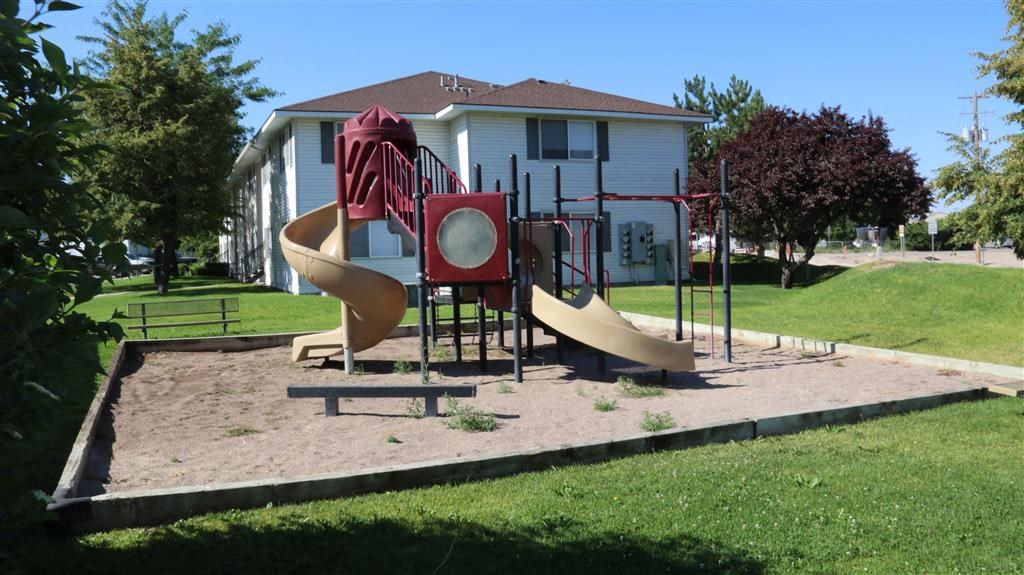 a playground with a house in the background