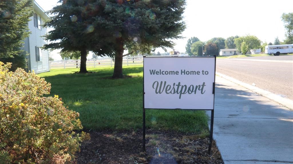 a sign that reads welcome home in front of a street