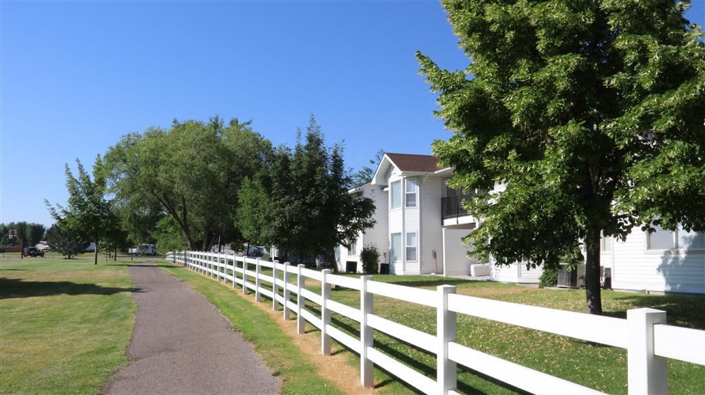 a white fence and a path in front of houses