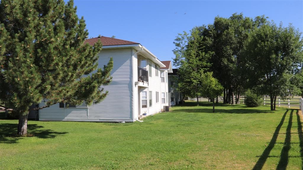 a white house with a yard and trees