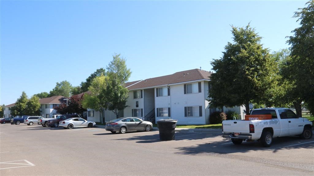 an empty parking lot in front of an apartment building