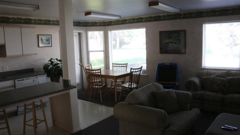 a living room and dining room with a table and chairs