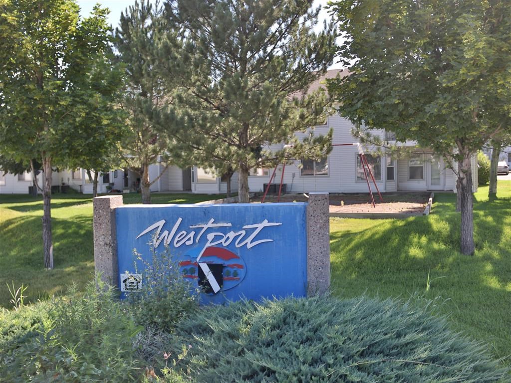 a sign in the grass in front of a building