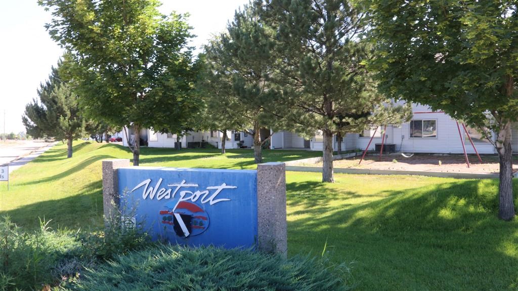 a sign in the grass in front of a building