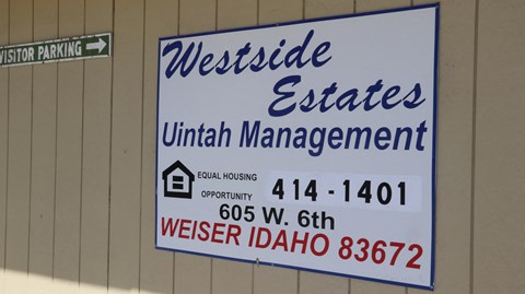 a sign on the side of a building that reads westside estates unit management
