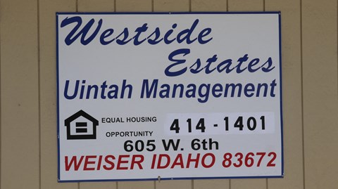 a sign for westside estates unit management on the wall of a building
