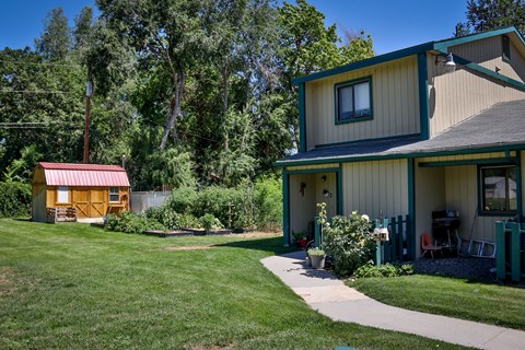 the exterior of a house with a yard and a shed