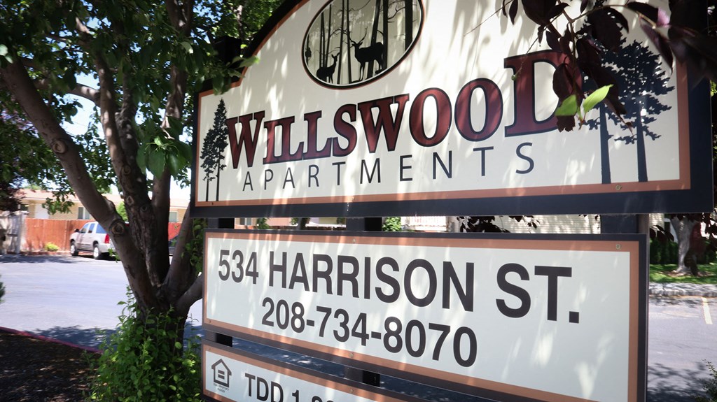 a sign for will sword apartments on the side of a street