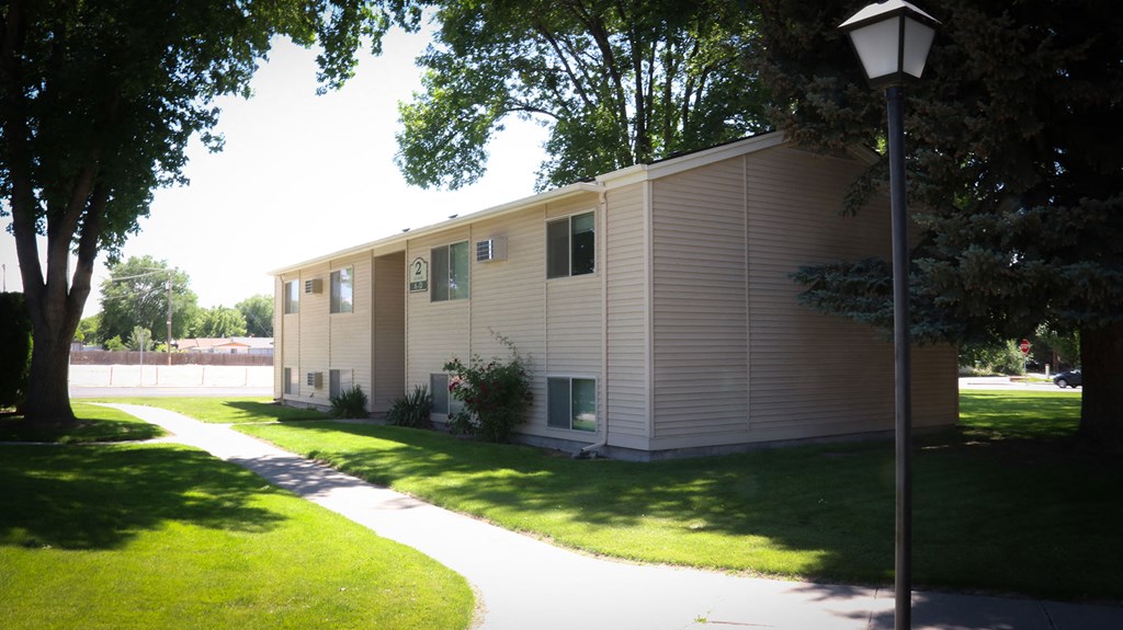 a white mobile home is parked next to a sidewalk