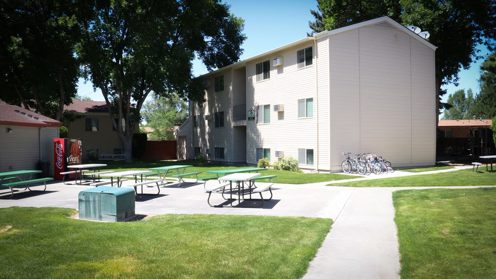 a large white building with picnic tables in front of it