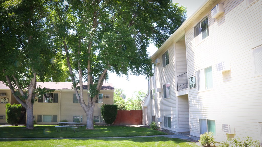 a view of a yard between two apartment buildings