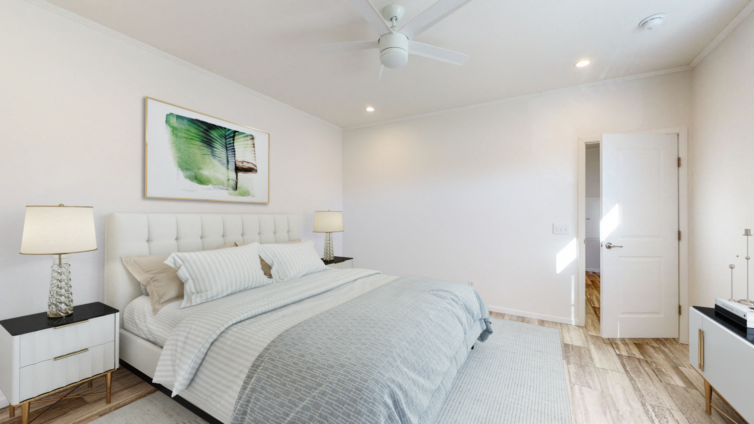a white bedroom with a bed and a ceiling fan