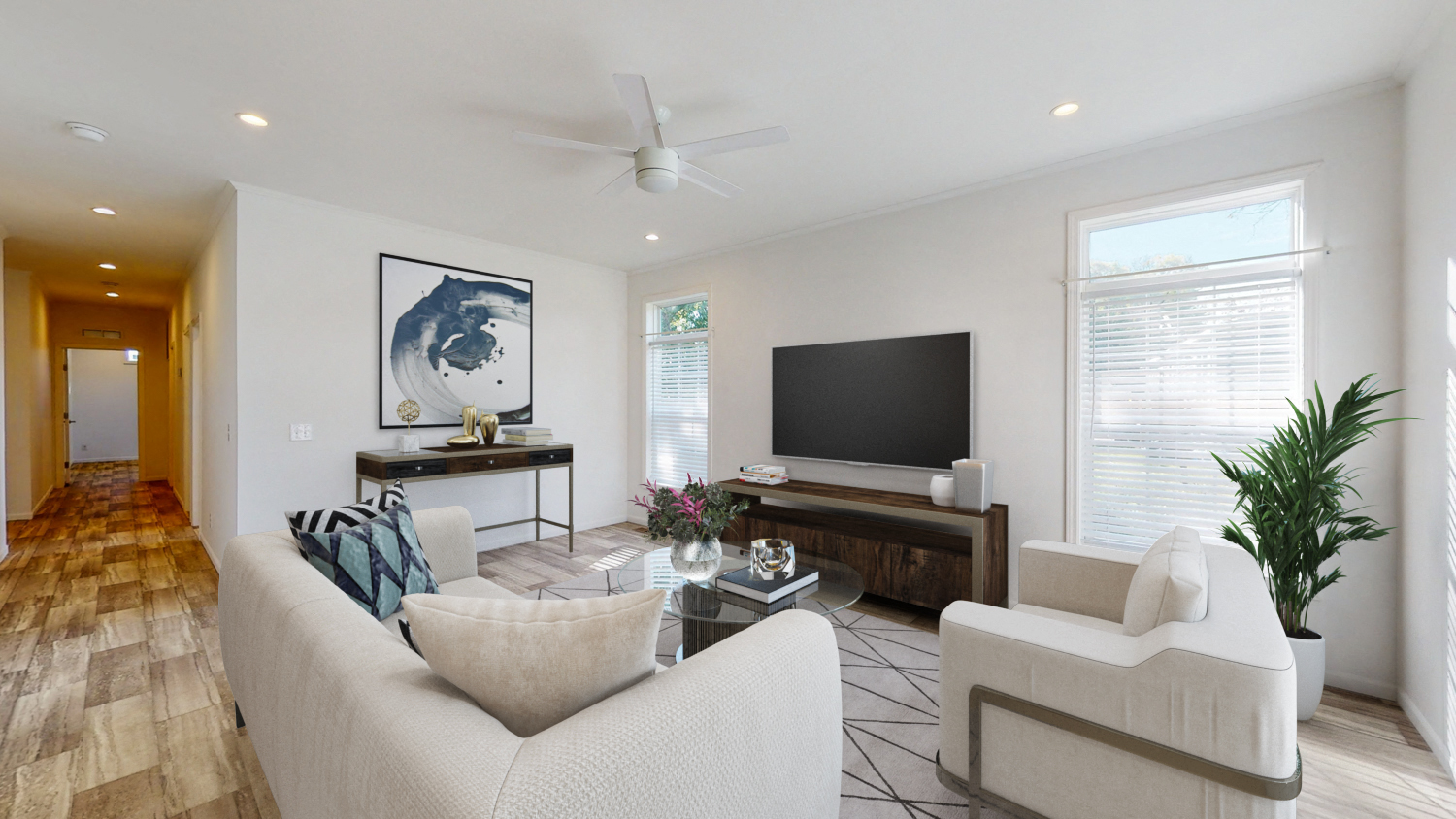 a living room with a white couch and a television